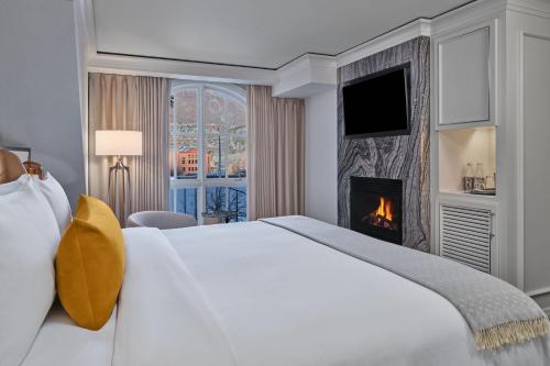 a bedroom with a white bed and a fireplace at St. Regis Aspen Resort in Aspen