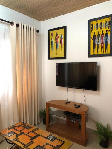 een woonkamer met een flatscreen-tv aan de muur bij short/long stay in Okponglo
