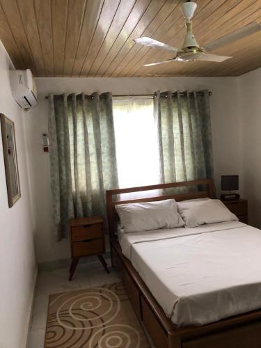 een slaapkamer met een bed en een raam bij short/long stay in Okponglo