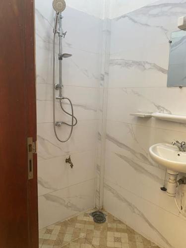 uma casa de banho com um chuveiro e um lavatório. em Appartement meublé deux pièces em Agblangandan