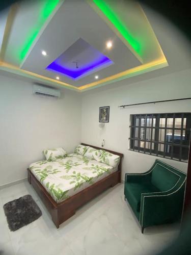 1 dormitorio con 1 cama y techo con luces verdes en Appartement meublé deux pièces, en Agblangandan