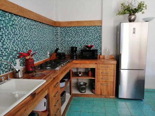 una cocina con nevera de acero inoxidable y armarios de madera en Los Huacales Apartamento, en Oaxaca City