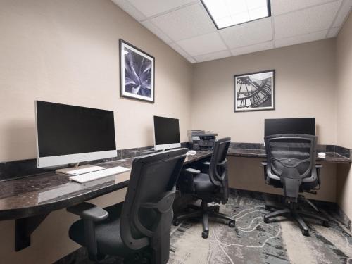 an office with two desks with two monitors and chairs at Holiday Inn Calgary Airport by IHG in Calgary