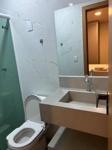 a bathroom with a sink and a toilet and a mirror at Loft Solaris Apart Hotel - Suíte - Apt. N.103 in João Câmara
