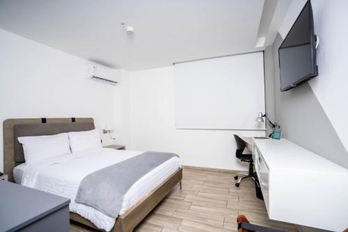 a bedroom with a bed and a flat screen tv at Hotel Puerto Pacifico Guayaquil Airport in Guayaquil