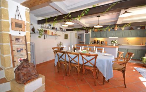 une cuisine et une salle à manger avec une table et des chaises dans l'établissement Cozy Home In St Quentin La Poterie, à Saint-Quentin-la-Poterie