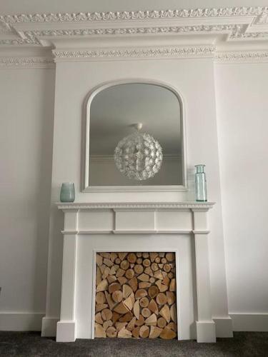 a white fireplace with a chandelier on top of it at Flat 1, Cromer in Cromer