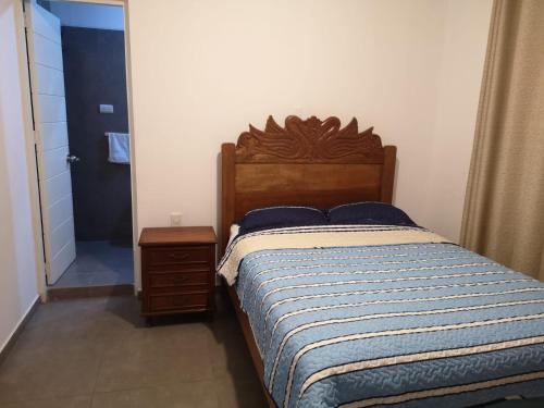 1 dormitorio con 1 cama con edredón azul y blanco en Chimor House, en Huanchaco