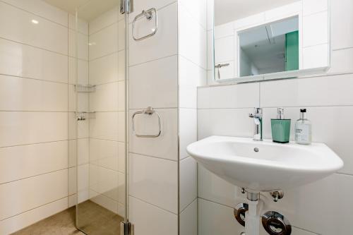 a white bathroom with a sink and a shower at Do Well Messe in Basel