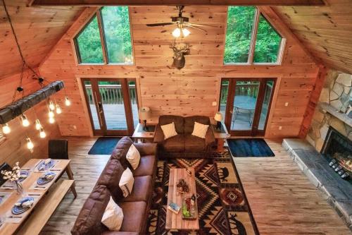 a living room of a wooden cabin with a couch at NEW HOT TUB! Secluded 3 Bed Cabin in Pigeon Forge in Pigeon Forge
