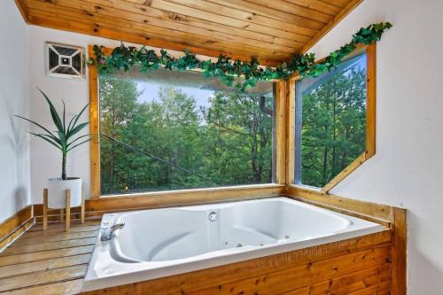 una grande vasca da bagno in una stanza con finestra di NEW HOT TUB! Secluded 3 Bed Cabin in Pigeon Forge a Pigeon Forge