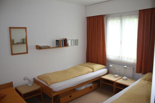 シュクオルにあるApartment Scuolの小さなベッドルーム(ベッド1台、窓付)