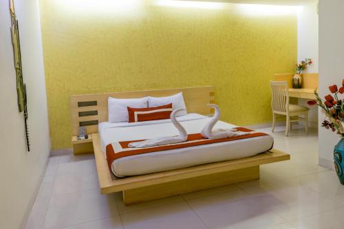 a bedroom with a bed with two swans on it at Octave Hotel & Spa - Marathahalli in Bengaluru