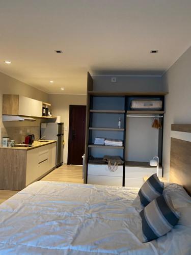 a bedroom with a bed and a kitchen at Frente al mar con pileta in Quequén