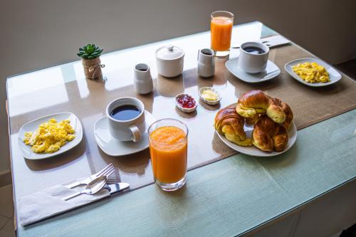 stół ze śniadaniem i sokiem pomarańczowym w obiekcie Zentra Hotel w mieście Chiclayo