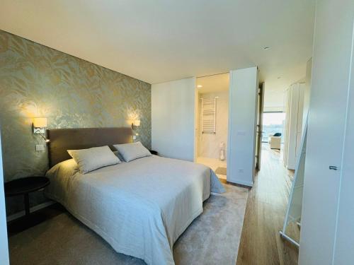 a bedroom with a large bed and a bathroom at Paradis bleu in Marinhas