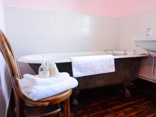 bañera antigua con toallas en una silla en el baño en 3 Bed in Dymchurch 46913, en Littlestone-on-Sea