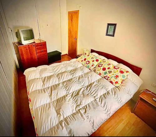 Un dormitorio con una cama con flores. en Cabaña con estacionamiento privado, en Llanquihue