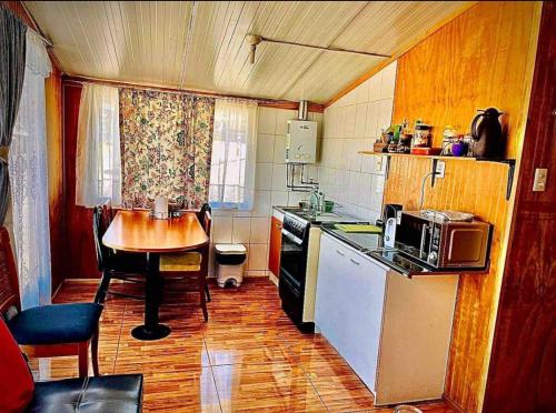 una pequeña cocina con mesa y encimera en Cabaña con estacionamiento privado, en Llanquihue