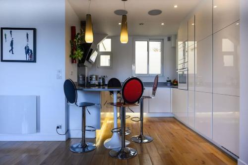 une cuisine avec deux tabourets de bar et un comptoir dans l'établissement Amazing Flat Near Parc Monceau, à Paris
