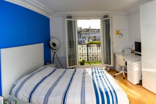 une chambre avec un lit, un bureau et une fenêtre dans l'établissement Amazing Flat Near Parc Monceau, à Paris