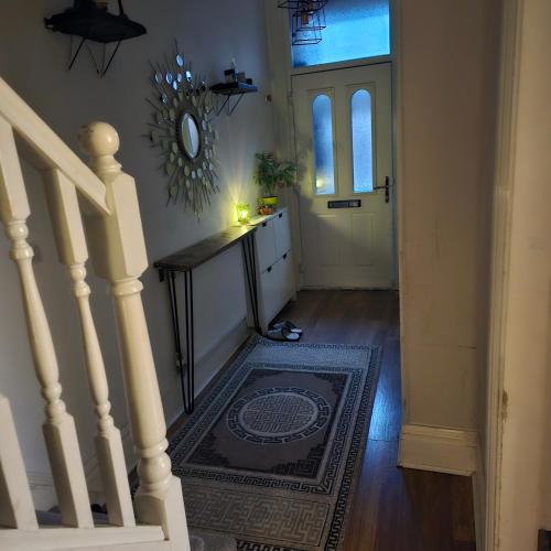 a hallway with a staircase and a door with a mirror at Shrewsbury 1 in Manchester