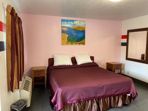 een slaapkamer met een bed en een schilderij aan de muur bij Laurel Inn in Oakland