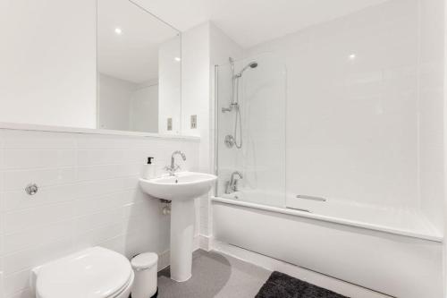 een witte badkamer met een toilet en een wastafel bij Khayat Homes - The Ferry - Two Bed in Londen