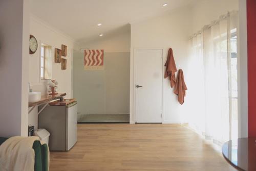 pasillo con puerta blanca y suelo de madera en Bulimba Studio en Brisbane