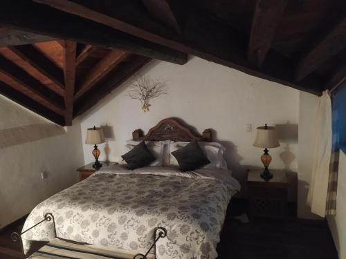 a bedroom with a large bed with two lamps at Cabañas "Rancho La Mesa" in Pátzcuaro