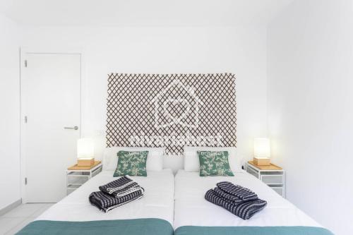 a bedroom with a white bed with two pillows at Ocean View El Pris, by Nivariahost in El Pris