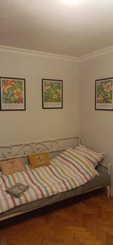 a bed in a room with three pictures on the wall at Apartament VvGogh 4 pokoje in Rzeszów