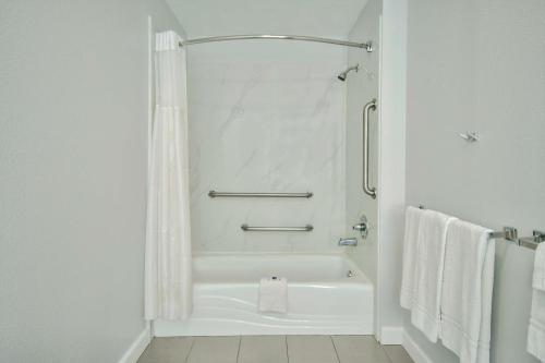 y baño blanco con bañera y ducha. en Motel 6 Houston, TX - I-10 West en Houston