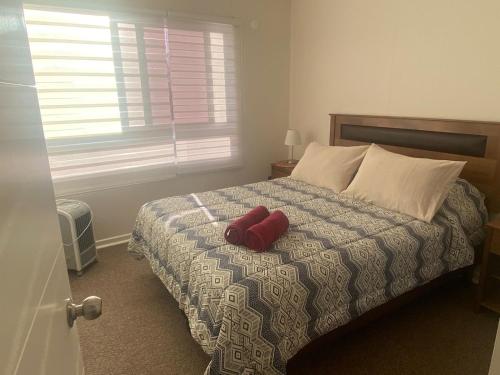um quarto com uma cama com um objecto vermelho em Hermosa casa amoblada dos dormitorios mas dos baños em Los Ángeles