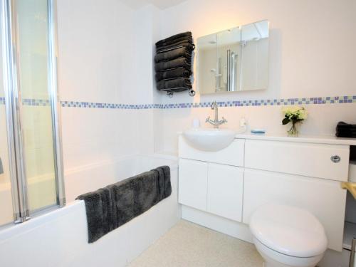 La salle de bains blanche est pourvue d'un lavabo, de toilettes et d'une baignoire. dans l'établissement 2 Bed in Moreton-In-Marsh 75870, à Whichford