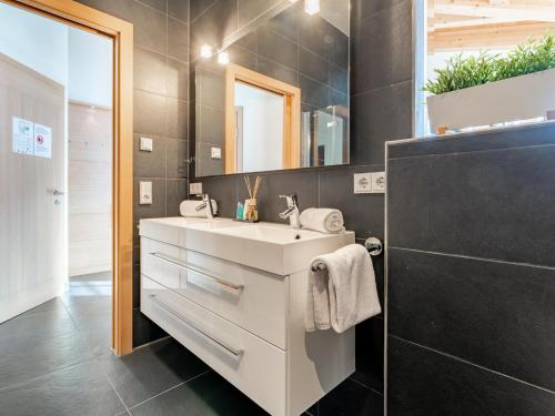 a bathroom with a white sink and a mirror at Chalet Erlebnishaus II in Piesendorf