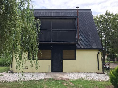 een huis met een zwart dak en een garage bij CASA 2 AGUAS MELINCUÉ in Melincué