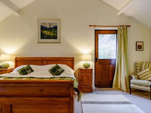 um quarto com uma cama, uma cadeira e uma janela em 5 Bed in Crickhowell BN365 em Llangattock