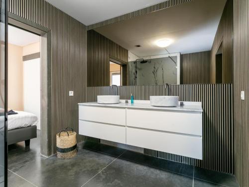 La salle de bains est pourvue d'un lavabo blanc et d'un miroir. dans l'établissement Ons Huis, à Rodenboom