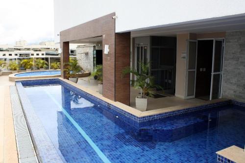 a swimming pool in front of a house at Noroeste Atrium Platine Apartamento Completo in Brasilia
