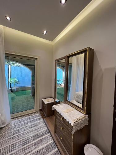 a bathroom with a large mirror and a window at DownTown New Cairo in Cairo