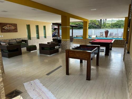 una sala de estar con mesas de ping pong y sofás en Casa Amarela, en Paranoá
