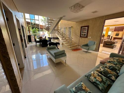 una sala de estar con sofás y sillas y una escalera en Casa Amarela, en Paranoá