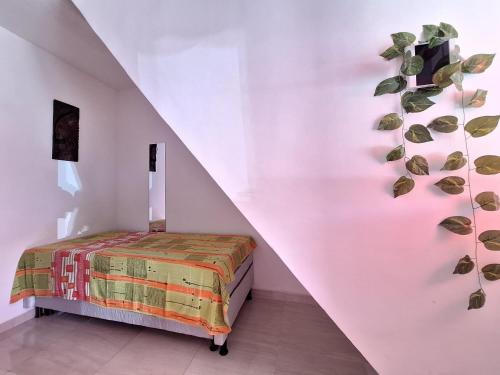 1 dormitorio con 1 cama con una planta en la pared en Mar.5: Compact close to Stella Maris beach and Airport en Salvador