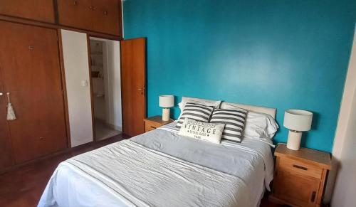 - une chambre dotée d'un lit avec un mur bleu dans l'établissement Calido Departamento en Belgrano, à Buenos Aires