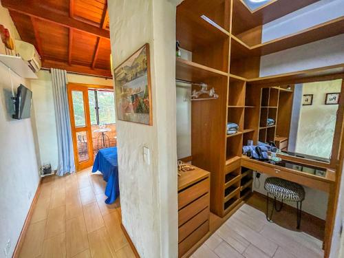Zimmer mit Holzwänden und einem Schreibtisch in einem Zimmer in der Unterkunft Ap Encontro dos Sonhos in Carrancas