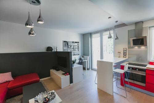 ルブリンにあるRGB studioのリビングルーム(赤いソファ付)、キッチン