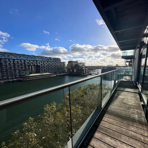 a balcony with a view of a river and buildings at Canary Wharf Apartments in London