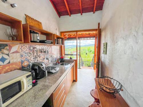 eine Küche mit einer Arbeitsplatte und einer Mikrowelle in der Unterkunft Ap Encontro dos Sonhos in Carrancas