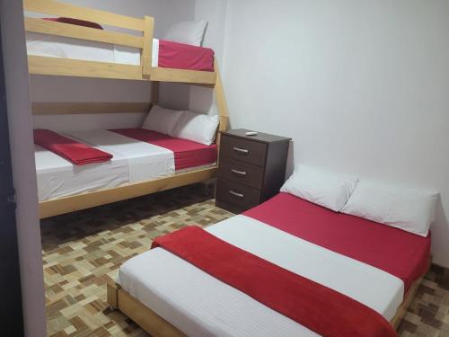 1 dormitorio con 2 literas con sábanas rojas y blancas en Apartahotel Los Ángeles en Cartagena de Indias